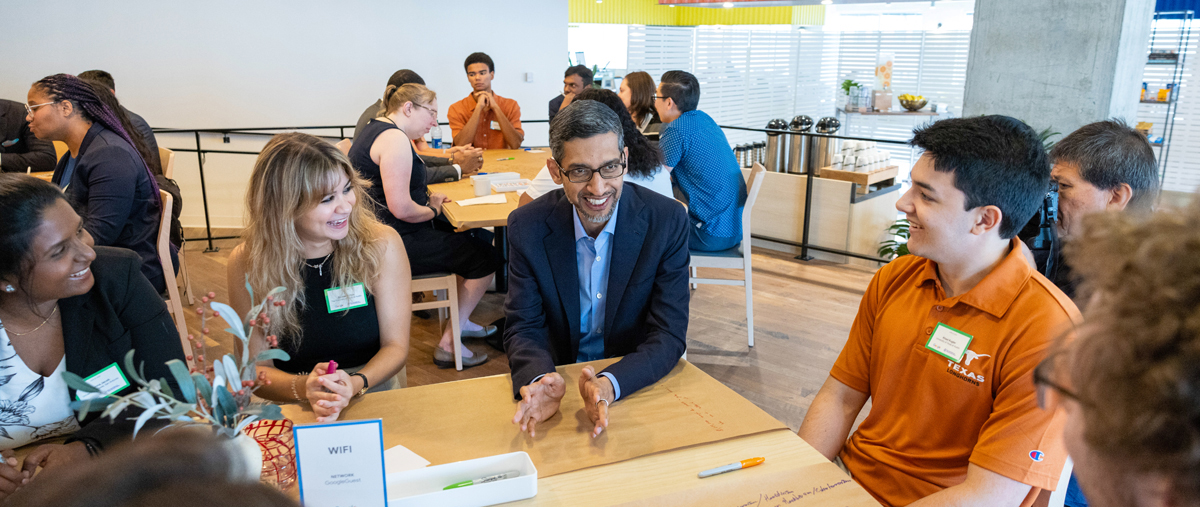 Google CEO Sundar Pichai sitting with a group of students.